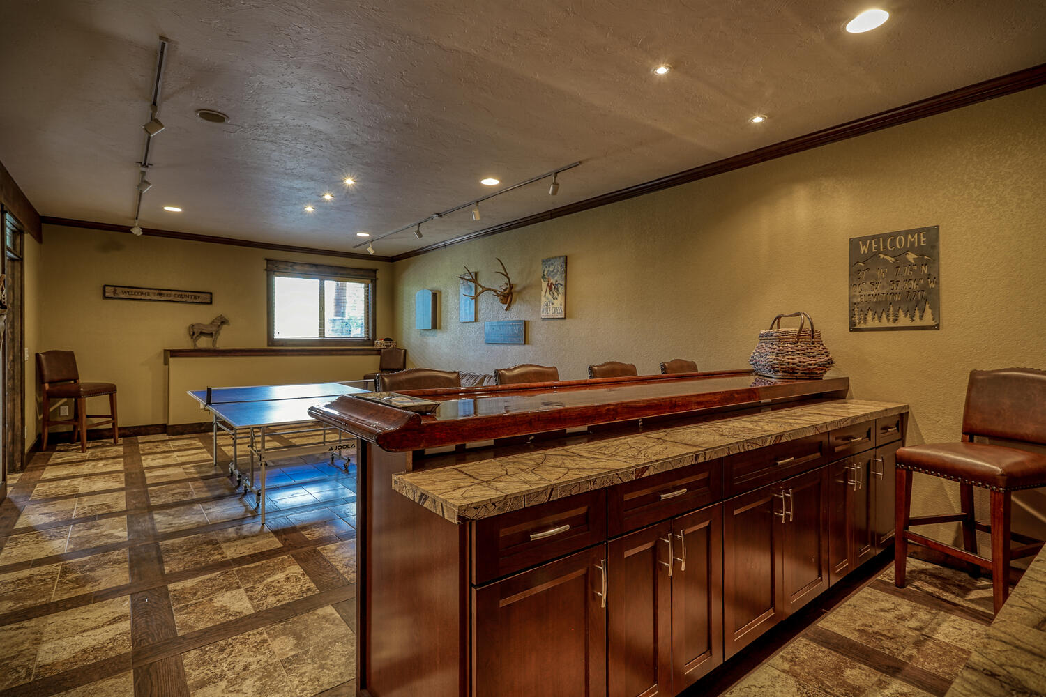 Bottom-level entertainment room with ping pong table and bar area with seating at Eagle's View vacation home